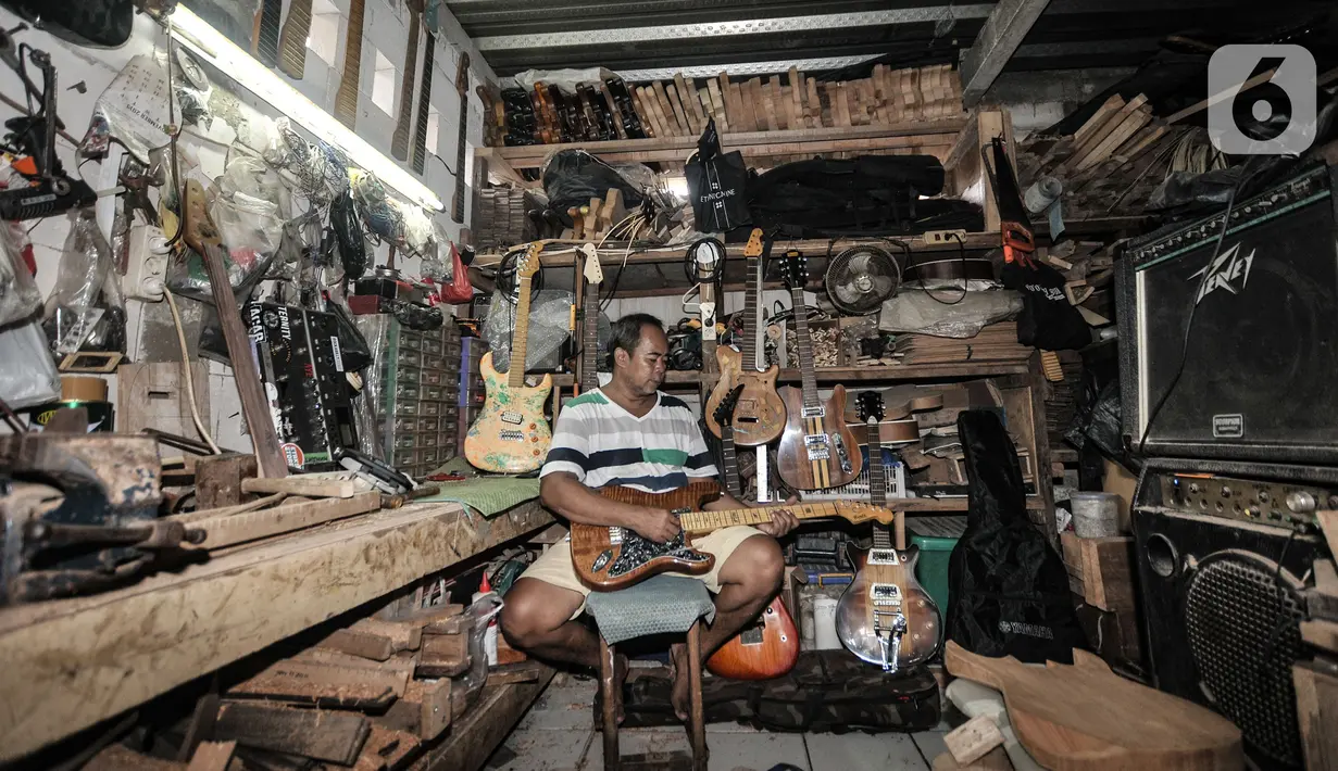 Potret Bone di sela aktivitasnya di workshop Bone's Costum Guitar, Jatinegara, Jakarta, Rabu (10/3/2021). Pandemi virus Corona menyebabkan usaha pembuatan dan servis gitar yang dirintis sejak 1989 itu nyaris tanpa pemasukan. (merdeka.com/Iqbal S Nugroho)