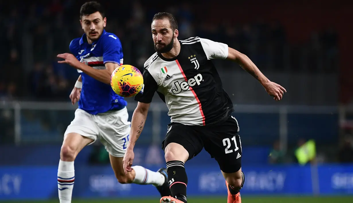 Penyerang Juventus, Gonzalo Higuain membawa bola dari kejaran pemain Sampdoria, Alex Ferrari  pada pertandingan lanjutan Liga Serie A Italia di stadion Luigi-Ferraris di Genoa (18/12/2019). Juventus menang tipis 2-1 atas Sampdoria. (AFP/Marco Bertorello)