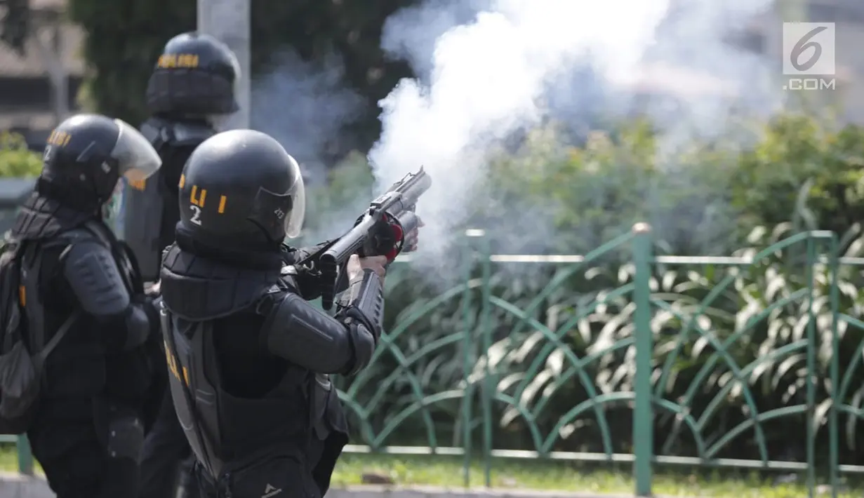 Polisi menembakan gas air mata ke arah massa aksi demo di Petamburan, Jakarta Barat, Rabu (22/5/2019). Hingga pukul 12.15 WIB, massa masih saling berhadap-hadapan dengan polisi di lokasi tersebut. (Liputan6.com/Faizal Fanani)