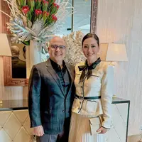 Tampilan elegan Maia Estianty rayakan Tahun Baru 2024 di California. Ia tampil menawan dengan tweed blazer dan rok plisket serba broken white, dipermanis dengan belt dan dasi pita berwarna hitam. [@maiaestiantyreal]