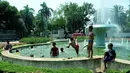 Sejumlah anak mandi bermain di bundaran air mancur Jalan Teuku Umar, Jakarta Pusat, Sabtu (23/9). Cuaca panas ibu kota memaksa anak-anak menceburkan diri di kolam untuk menyejukkan badan. (Liputan6.com/Helmi Afandi)