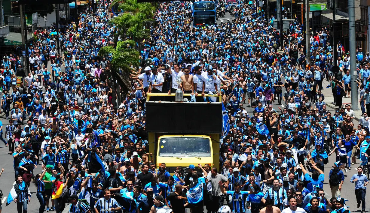 Pemain dan suporter Gremio merayakan keberhasilan meraih juara Copa Libertadores dengan pawai di Porto Alegre, Brasil, Kamis (30/11/2017). Gremio menjadi juara Copa Libertadores setelah mengalahkan Lanus dengan skor agregat 3-1. (AFP/Itamar Aguiar)