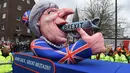 Patung menyerupai PM Inggris Theresa May dengan pistol bertulisan "Brexit" ikut dalam karnaval tradisional 'Rose Monday' di Dusseldorf, Jerman, Senin (27/2). Karnaval 'Rose Monday' berisi sindiran satir para pemimpin dunia. (AFP PHOTO / Patrik STOLLARZ)