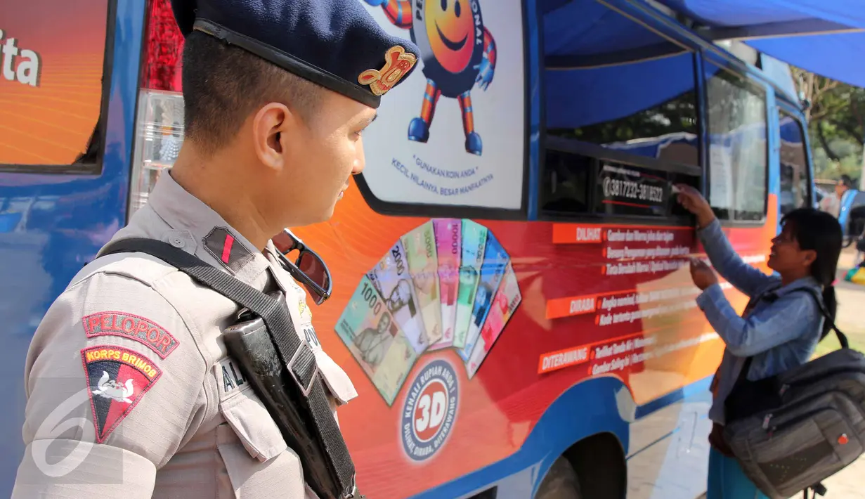 Seorang polisi berjaga ditempat penukaran uang pada layanan mobil kas keliling Bank Indonesia di Lapangan IRTI, Monas, Jakarta, Kamis (2/7). Sebanyak 15 bank membuka gerai penukaran uang pecahan hingga 15 Juli mendatang. (Liputan6com/Helmi Afandi)