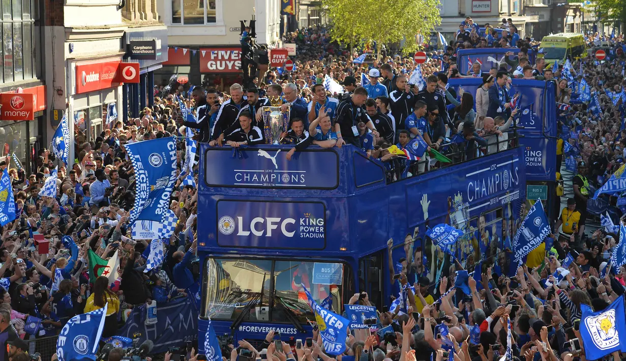 Tima Leicester City berkeliling kota Leicester City dengan trofi Liga Inggris saat disambut ribuan fans, (16/5/2016). (AFP/Glyn Kirk)