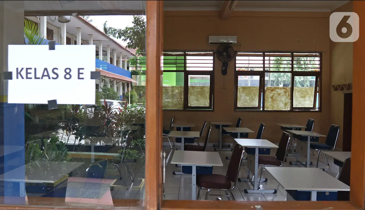 Suasana ruang kelas kosong saat PTMT dihentikan di SMPN 2 Depok, Pancoran Mas, Depok, Jawa Barat, Jumat (19/11/2021). Pelaksanaan PTMT sementara hingga 29 November 2021 akibat terjadinya penambahan kasus COVID-19 yang berasal dari klaster PTMT. (Liputan6.com/Herman Zakharia)