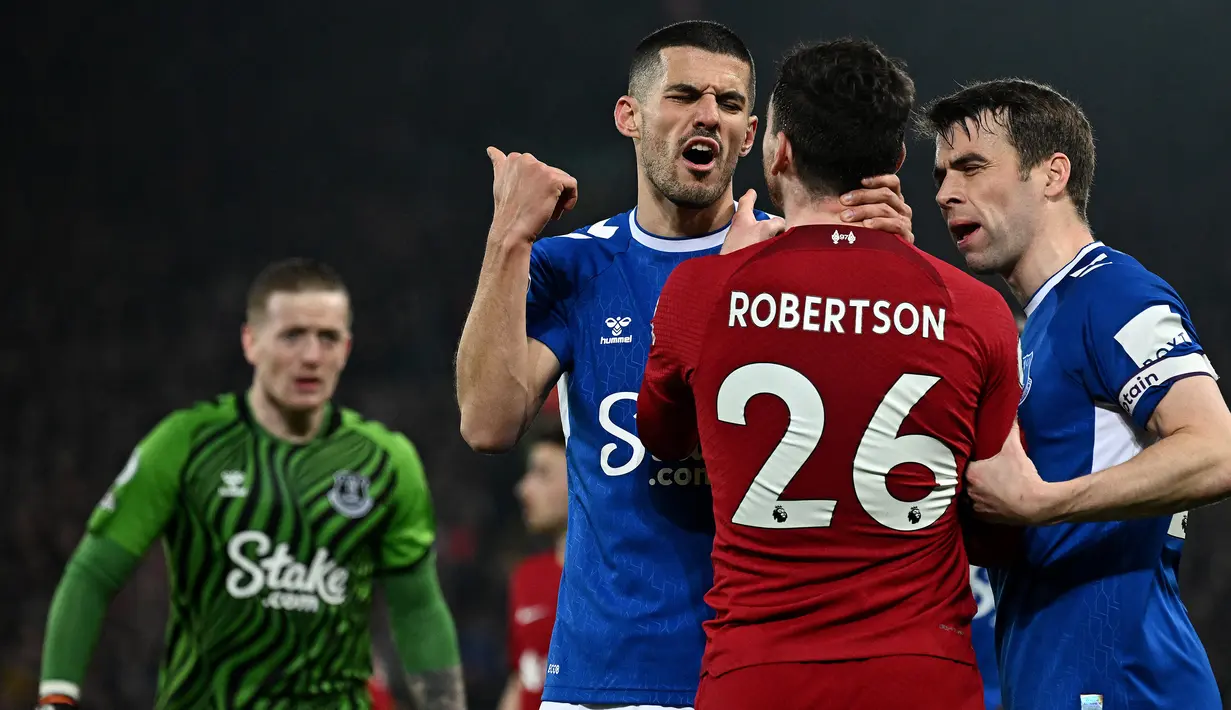 Pemain Everton, Seamus Coleman dan Conor Coady, bersitegang dengan pemain Liverpool, Andrew Robertson, pada laga Liga Inggris di Stadion Anfield, Selasa (14/2/2023). Derby Merseyside memang dikenal sebagai salah satu duel dua tim satu kota paling panas di Inggris. (AFP/Paul Ellis)