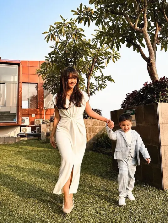 Fuji tampil elegan nan keibuan dengan mengenakan dress putih panjang model knot di bagian depan. [@fuji_an]