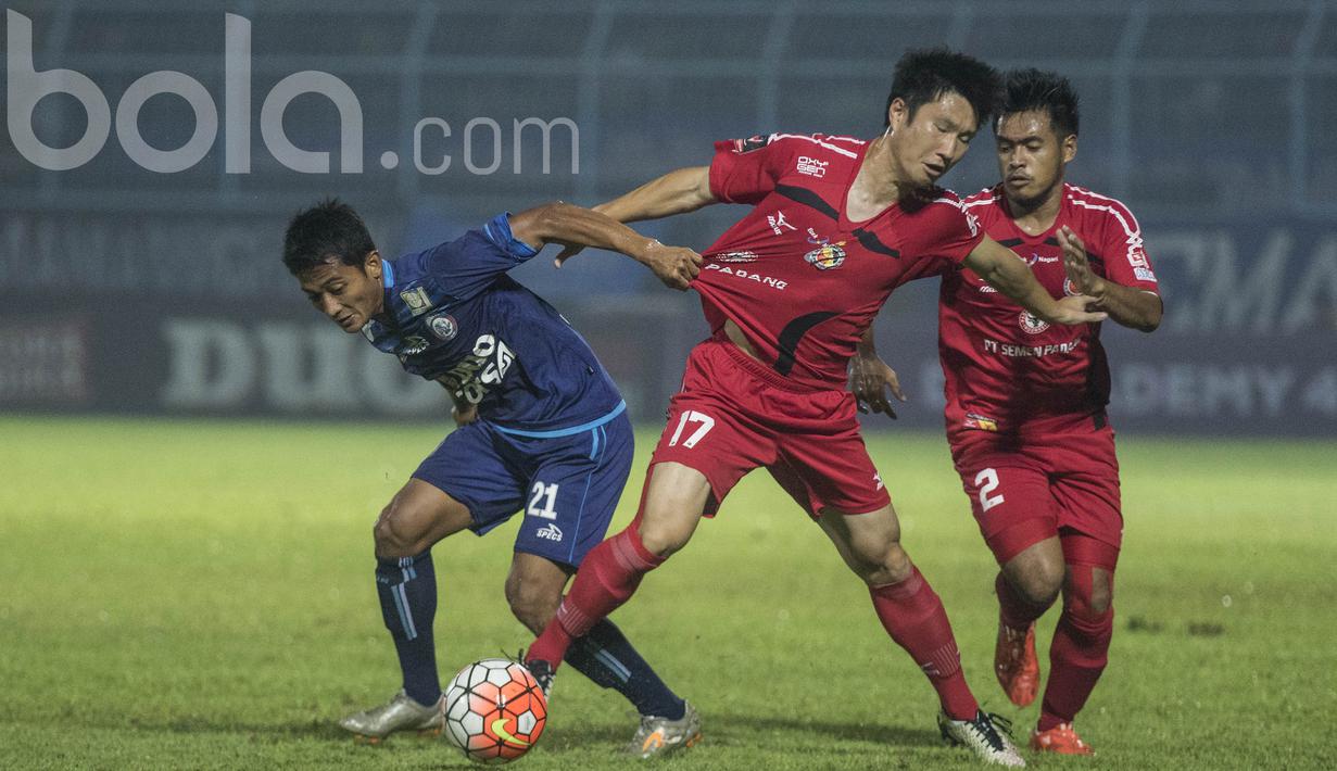 Gelandang Arema, Nasir, berebut bola dengan gelandang Semen Padang, Ko Jae-sung. Tertinggal 0-2 membuat Singo Edan tertinggal agregat 1-3, namun mereka pantang menyerah dan terus menggempur pertahanan tim tamu. (Bola.com/Vitalis Yogi Trisna)