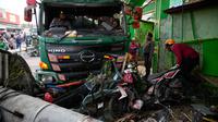 Polisi membersihkan puing-puing pascakecelakaan lalu lintas di Bekasi, Indonesia, Rabu (31/8/2022). Korban meninggal adalah siswa SD dan pedagang. (AP Photo/Achmad Ibrahim)