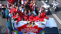 Atlet Indonesia peraih medali Olimpiade Rio 2016 yang ikut dalam arak-arakan terlihat melambaikan tangan saat melintas menuju Istana Negara, Jakarta, Rabu (24/8). Arak-arakan ini dikawal puluhan pengendara motor gede alias Moge (Liputan6.com/Angga Yuniar)