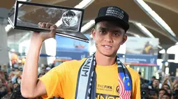 Pesepak bola Malaysia, Mohd Fauz Subri, memamerkan penghargaan FIFA Puskas Award yang diraihnya kepada publik negeri jiran. (AFP/Mohd Rasfan)