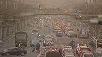 Mobil dan pejalan kaki menyusuri jalan yang diselimuti debu dan kabut di Beijing, Jumat, 10 Maret 2023. Pencakar langit menghilang ke dalam kabut dan kualitas udara anjlok saat ibu kota China diselimuti badai debu dan polusi berat. (AP Photo/Mark Schiefelbein)
