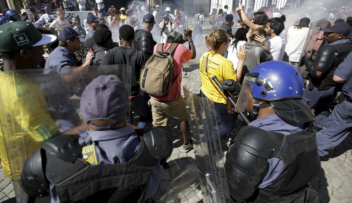 Polisi bentrok dengan pelajar di luar Parlemen Afrika Selatan di Cape Town, Rabu (21/10). Polisi anti huru hara menembakkan gas airmata kepada ratusan pelajar yang berdemonstrasi menentang rencana kenaikan uang sekolah. (REUTERS/Mark Wessels)