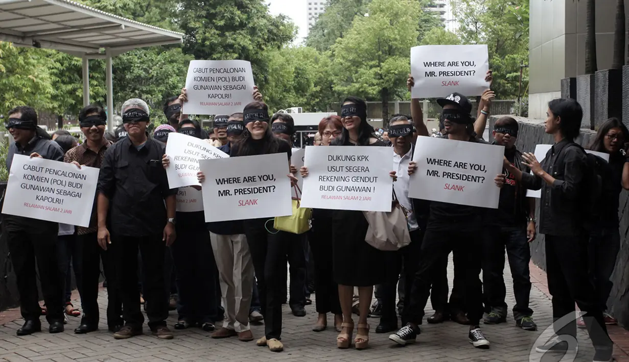 Koalisi masyarakat sipil yang terdiri dari pegiat antikorupsi, seniman, dan tokoh masyarakat berjalan bersama dengan mata tertutup di halaman gedung KPK, Jakarta, Kamis (15/1/2015). (Liputan6.com/Miftahul Hayat)