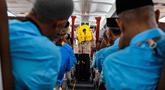 Para calon jemaah haji Indonesia menyimak cara menggunakan jaket penyelamat dari awak kabin di dalam pesawat Boeing 717 yang sudah tidak digunakan lagi selama sesi pelatihan keselamatan pra-keberangkatan di pusat embarkasi haji Banda Aceh pada Kamis 14 Mei 2026. (CHAIDEER MAHYUDDIN/AFP)