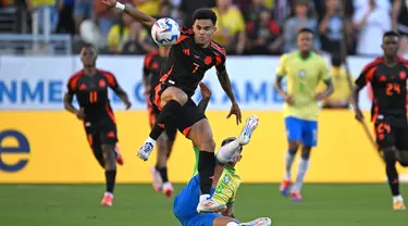 Penyerang Kolombia, Luis Diaz (atas) berebut bola dengan gelandang Brasil Bruno Guimaraes saat pertandingan grup D Copa America 2024 di Stadion Levi's, Santa Clara, California pada 2 Juli 2024 atau Rabu 3 Juli 2024 WIB. (Patrick T. Fallon/AFP)