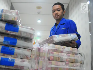 Karyawan memeriksa pasokan uang di Cash Pooling Bank Mandiri, Jakarta, Kamis (9/5/2019). Bank Mandiri menyiapkan dana tunai sebesar Rp 54,9 triliun pada Ramadan dan jelang Idul Fitri 2019. (Liputan6.com/Angga Yuniar)