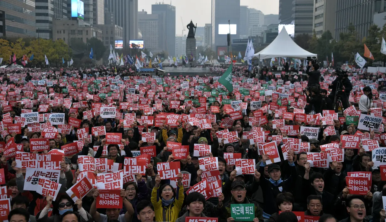 Ribuan warga Korsel membawa poster menuntut pengunduran diri Presiden Park Geun-Hye, di Gwanghwamun square, pusat Kota Seoul, Sabtu (5/11). Presiden Park didesak mundur terkait skandal korupsi yang telah melumpuhkan pemerintahannya. (Ed Jones/AFP)