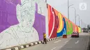 Pekerja menyelesaikan pembuatan mural di Flyover Gaplek, Tangerang Selatan, Rabu (10/3/2021). Konsep muralnya adalah "Tangsel Membangun". (Liputan6.com/Faizal Fanani)