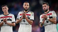 Pemain Manchester United, Manuel Ugarte, Noussair Mazraoui, dan Bruno Fernandes (kiri ke kanan) bertepuk tangan kepada para penggemar di akhir Liga Premier Inggris melawan Crystal Palace di Selhurst Park, London, Sabtu, 21 September 2023. (AP Photo/Kin Cheung)