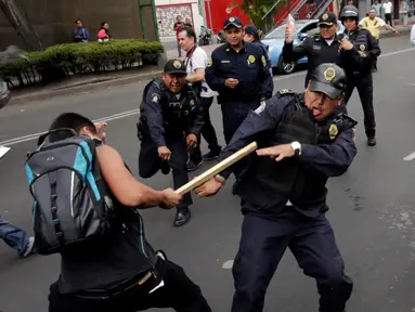 Seorang demonstran memukul polisi dengan kayu saat bentrokan terjadi memprotes penentangan adu banteng di luar arena adu banteng di Mexico City, Meksiko 29 Mei 2016. (REUTERS / Henry Romero)