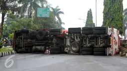 Kondisi sebagian ruas Jalan Tegar Beriman Kabupaten Bogor yang tertutup truk tangki BBM yang terbalik Jumat (15/4/2016). Menurut warga, truk tangki bermuatan 24.000 liter tersebut terbalik sekitar pukul 05.00 dini hari. (Liputan6.com/Helmi Fithriansyah)