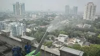 Petugas mengoperasikan mesin water mist sebagai upaya menekan polusi udara dan mengurangi hawa panas selama musim kemarau. ANTARA FOTO/Sulthony Hasanuddin/nz