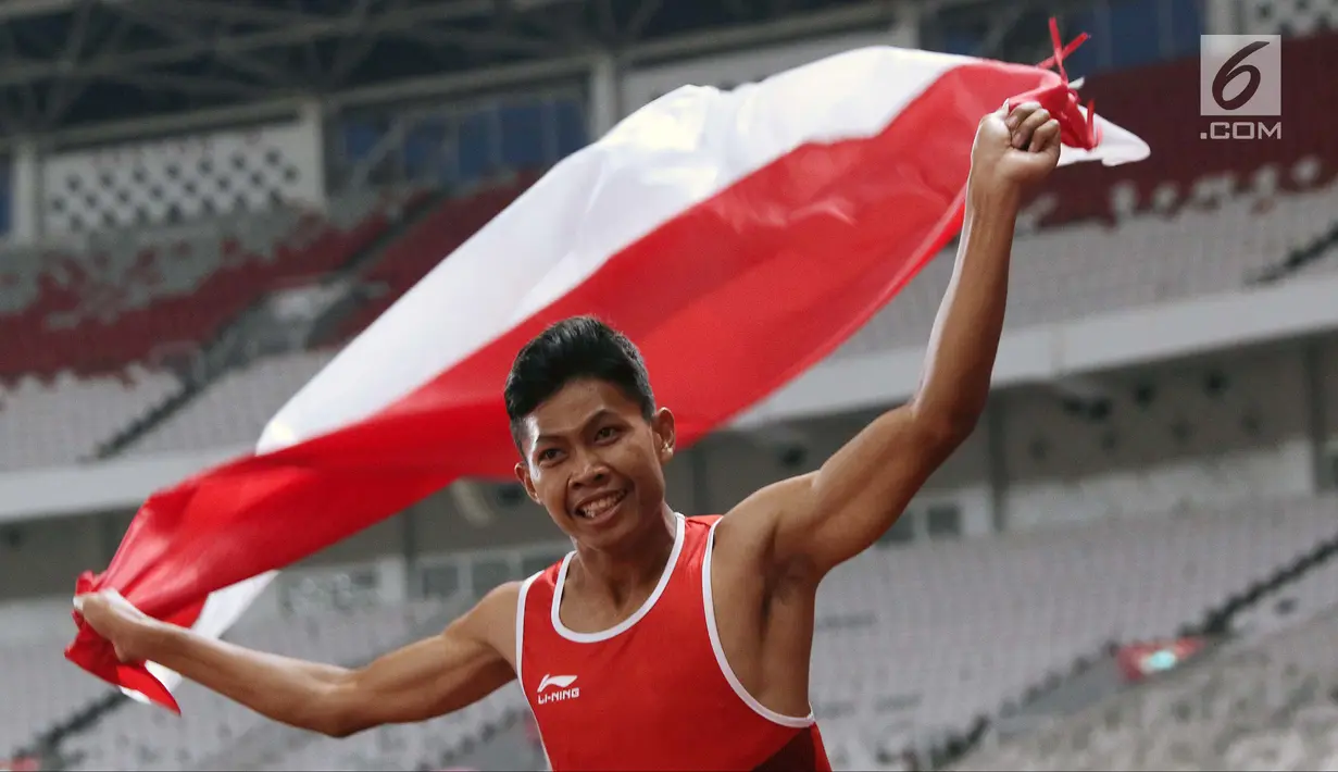 Atlet para-atletik Indonesia, Sapto Yogo Purnomo merayakan kemenangan lari nomor 100 meter T37 pria yang digelar di Stadion GBK, Jakarta, Selasa (9/10). Ini menjadi medali emas kedua Sapto di Asian Para Games 2018. (Liputan6.com/Helmi Fithriansyah)