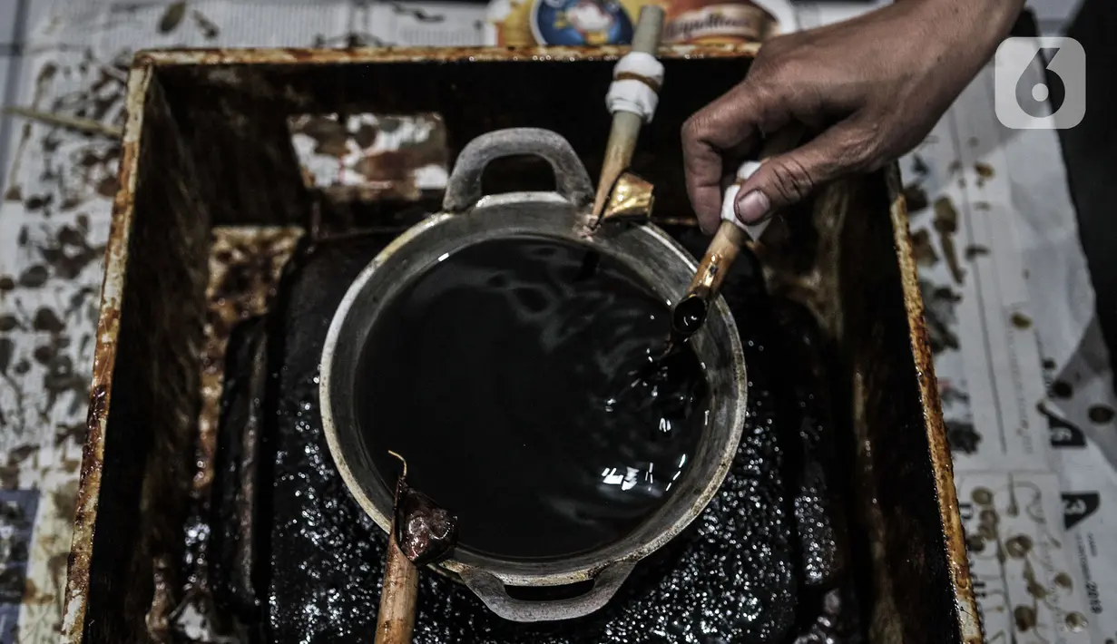 Perajin menyelesaikan pembuatan batik edisi Jakarta Terkini di Rumah Batik Palbatu, Kamis (15/10/2020). Kain batik Jakarta Terkini bergambar virus Covid-19 dipadukan ikon-ikon Ibu Kota seperti Monas, Tanjidor, dan ondel-ondel dibanderol Rp250 ribu - Rp350 ribu per buah. (merdeka.com/Iqbal Nugroho)