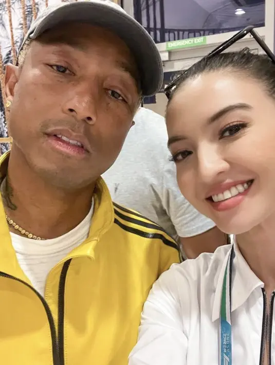 Mengunjungi F1 di Abu Dhabi, Raline yang mengenakan kemeja putih dari Prada bertemu penyanyi Pharrell William.  Credit:  (@ralineshah)