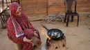 Seorang wanita menggunakan kayu pomace (ampas) sebagai bahan bakar untuk memasak di rumahnya di Kota Khan Younis, Jalur Gaza, Palestina, 7 November 2020. Pekerja Palestina mengubah limbah produksi minyak zaitun menjadi kayu pomace yang dapat digunakan sebagai bahan bakar. (Xinhua/Rizek Abdeljawad)
