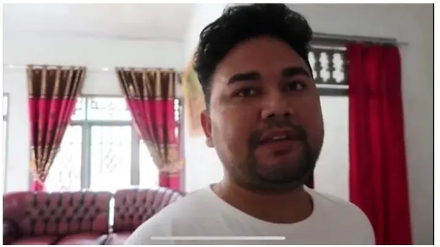 Memasuki ruang tamu di rumah host berbakat ini, terdapat sofa vintage serta perpaduan gorden emas dan merah.