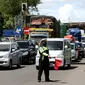 Polisi melakukan sistem buka tutup jalan menuju Pelabuhan Merak, Cilegon, Banten, Jumat (29/4/2022). Sistem buka tutup tersebut membuat kemacetan panjang hingga ke dalam Tol Tangerang-Merak. (Liputan6.com/Angga Yuniar)