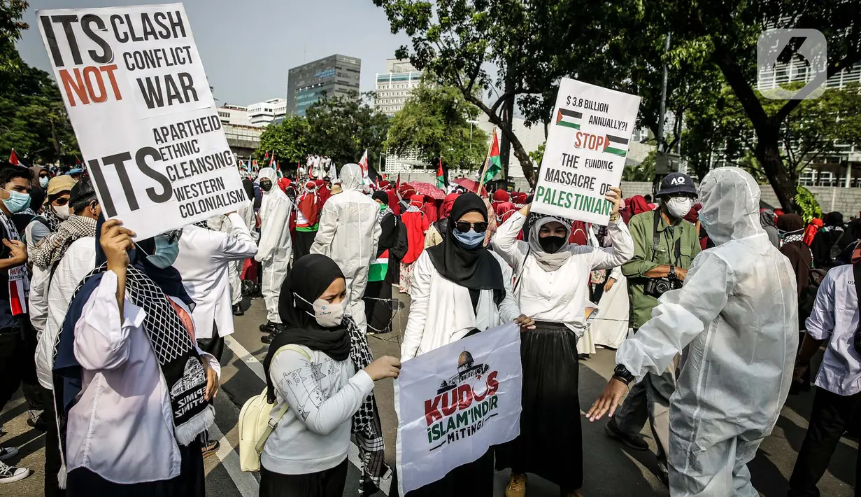 Petugas Satgas COVID-19 dari personel kepolisian meminta peserta aksi solidaritas untuk Palestina menjaga protokol kesehatan di depan Kedutaan Besar AS, Jakarta, Selasa (18/5/2021). Massa mengutuk dan mengecam keras kekerasan yang dilakukan Israel atas Palestina. (Liputan6.com/Faizal Fanani)