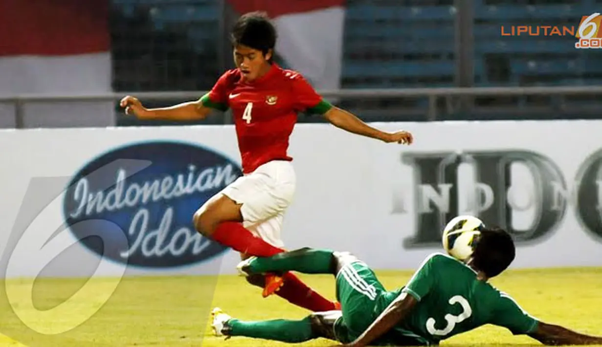 Bayu Gatra (4) melompat menghindari tackling keras pemain belakang Maladewa Mohamed Samdhooh (Liputan6.com/Helmi Fithriansyah) 