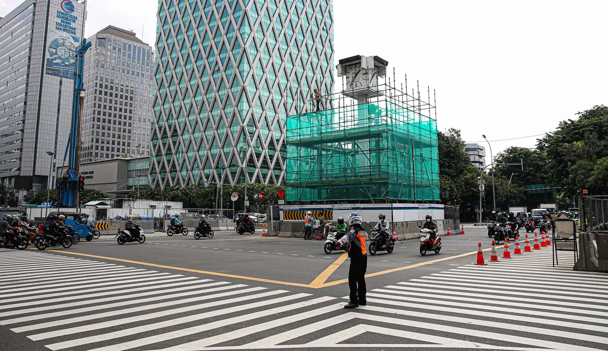 Pekerja memasang penutup di Tugu Jam Thamrin, Jakarta, Kamis (18/11/2021). PT MRT Jakarta (Perseroda) dalam waktu dekat akan memindahkan sementara Tugu Jam Thamrin di Jakarta Pusat yang merupakan bangunan cagar budaya. (Liputan6.com/Faizal Fanani)