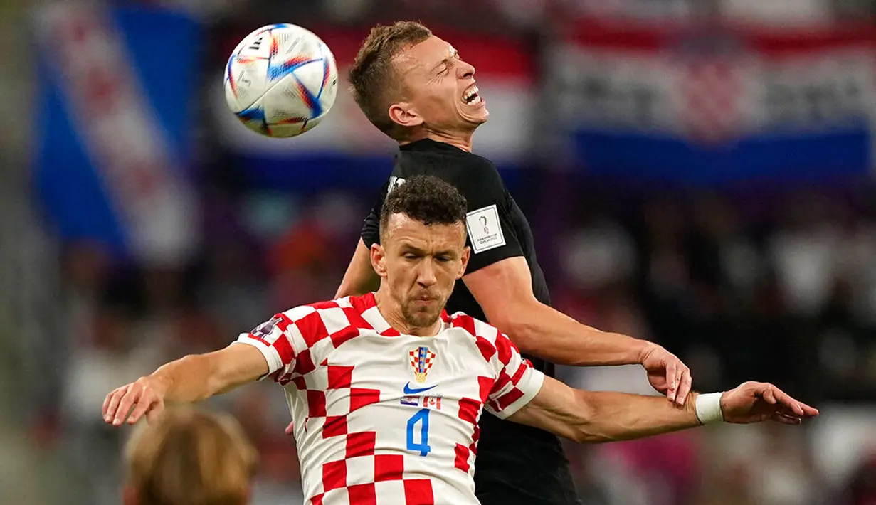 Pemain Kanada Alistair Johnston (atas) berebut bola dengan pemain Kroasia Ivan Perisic pada pertandingan sepak bola Grup F Piala Dunia 2022 di Stadion Internasional Khalifa, Al Rayyan, Qatar, 27 November 2022. Kroasia mengalahkan Kanada dengan skor 4-1. (AP Photo/Martin Meissner)