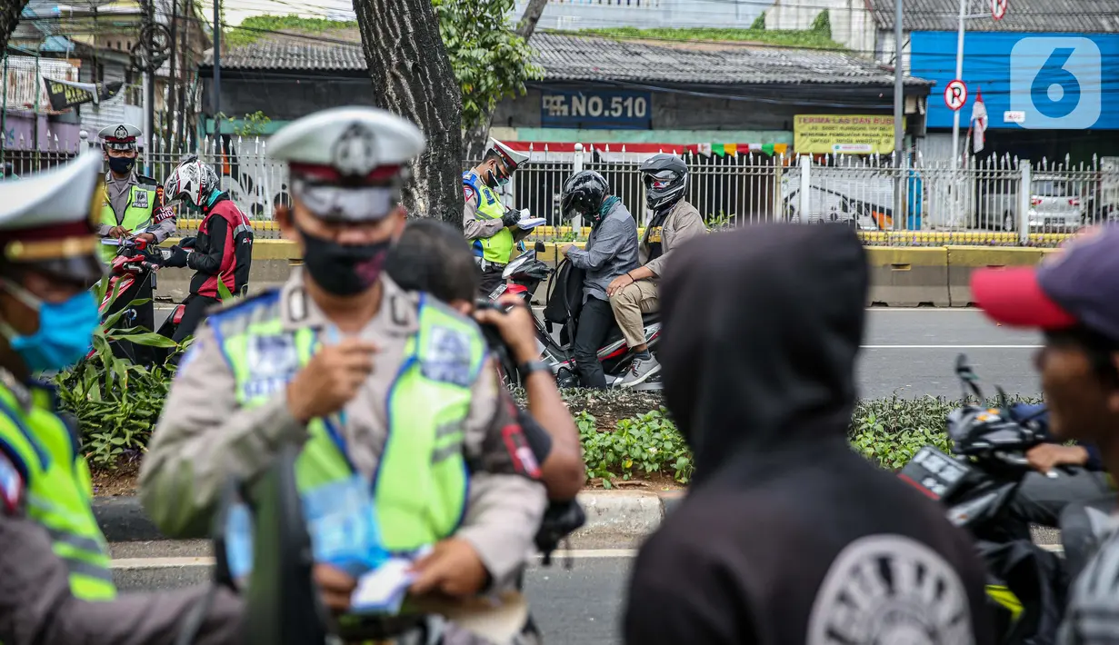 Polisi Lalu lintas menilang pengendara sepeda motor saat Operasi Patuh Jaya 2020 di Jalan Letjen Suprapto, Jakarta Pusat, Kamis (23/7/2020). Ditlantas Polda Metro Jaya menggelar Operasi Patuh Jaya 2020 hingga 5 Agustus untuk menertibkan masyarakat dalam berlalu lintas. (Liputan6.com/Faizal Fanani)