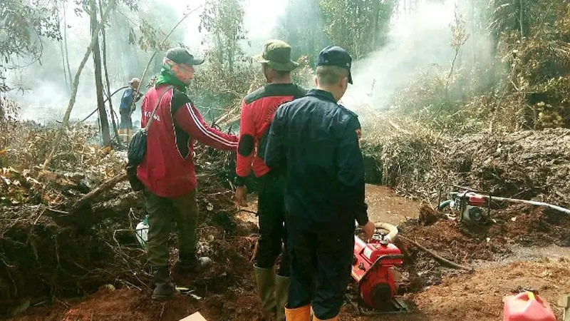 Personel BBKSDA Riau dan Manggala Agni memadamkan kebakaran lahan di SM Giam Siak Kecil, Kabupaten Bengkalis.