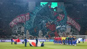 Koreografi raksasa dari suporter La Grande bergambar raksasa bergambarkan pertarungan antara Gundala dan Godzilla, serta tulisan "Untungnya Ku Tak Pilih Menyerah" di sisi kiri dan kanannya saat laga lanjutan putaran ketiga Grup C Kualifikasi Piala Dunia 2026 antara Timnas Indonesia melawan Jepang di Stadion Utama Gelora Bung Karno (SUGBK), Senayan, Jakarta, Jumat (15/11/2024). (Bola.com/Bagaskara Lazuardi)