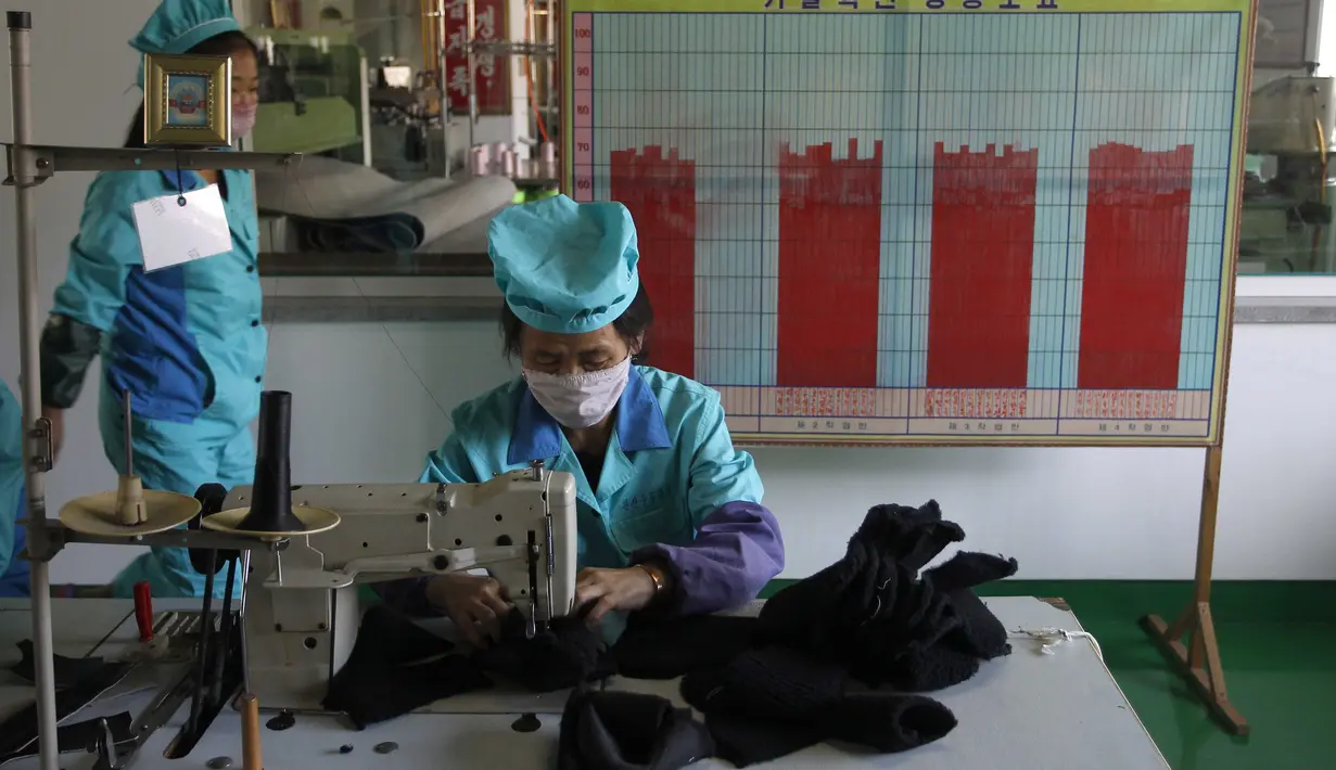 Pekerja memakai masker di Pabrik Sepatu Kulit Wonsan, tempat mereka memproduksi sepatu kulit buatan tangan di Wonsan, Provinsi Kangwon, Korea Utara pada 28 Oktober 2020. (AP Photo/Jon Chol Jin)