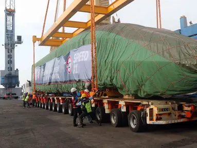 Pekerja dengan dibantu alat berat menurunkan rangkaian kereta cepat di Pelabuhan Tanjung Priok, Jakarta Utara, Jumat (2/9/2022). PT KCIC mengatakan dua trainset atau rangkaian kereta cepat telah tiba. (Liputan6.com/Herman Zakharia)