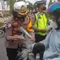 Personel Lalu Lintas Polda Riau memberikan hadia kepada pengguna jalan yang tertib pada Operasi Zebra Lancang Kuning. (Liputan6.com/M Syukur)