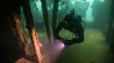 Seorang penyelam mengambil video sambil menjelajahi kapal karam di Pantai Ancon, pinggiran Lima, Peru, Minggu (27/3). Sekolah menyelam di Peru membawa siswa mereka ke situs ini untuk tamasya khusus. (AP Photo/Rodrigo Abd)