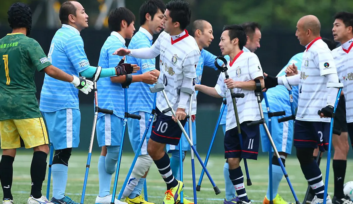 Para pemain dari Pemain FC Kyushu Bairaor (biru) dan FC Alvorada Kawasaki bersalaman sebelum memulai pertandingan di Fujitsu Stadium Jepang. FC Kyushu Bairaor juara dalam pertandingan ini. (Aflo/Rex Shutterstock/Dailymail)
