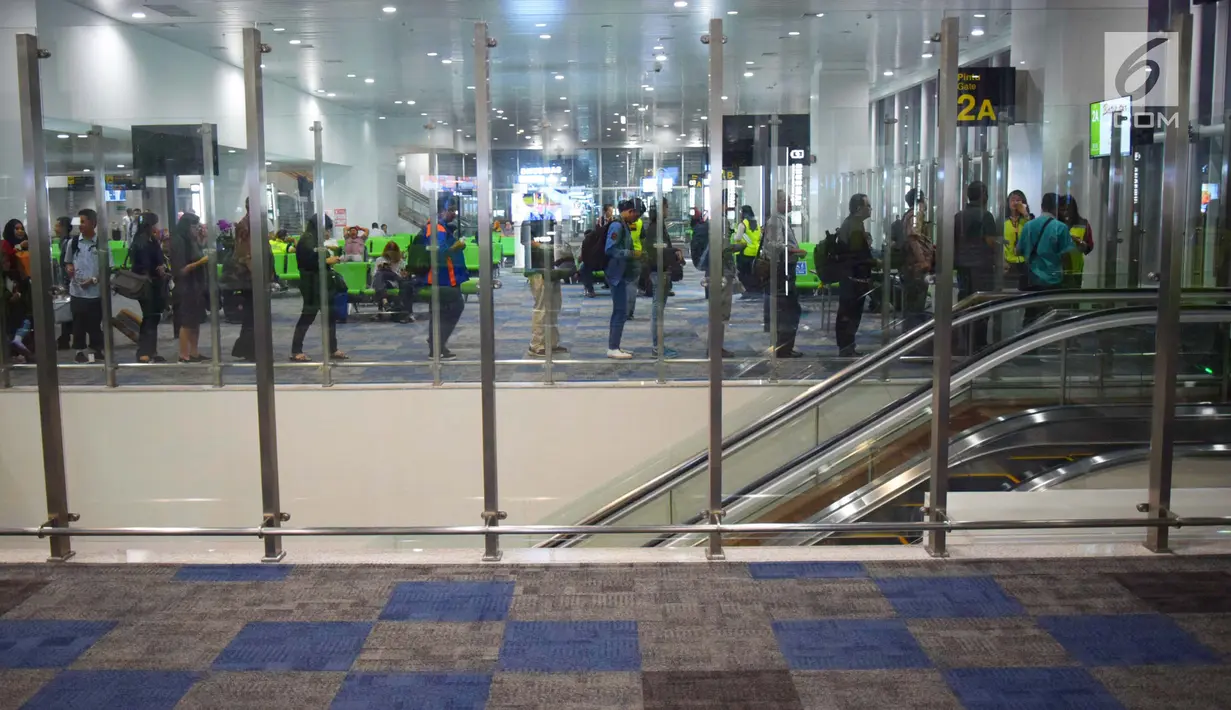 Calon penumpang antre untuk masuk pesawat melalui boarding gate di terminal baru Bandara Internasional Ahmad Yani Semarang, Rabu (6/6). Terminal yang dibangun dengan investasi sebesar Rp2,2 triliun tersebut mulai beroperasi hari ini. (Liputan6.com/Gholib)