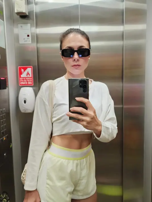 Miror selfie sebelum olahraga, Wulan Guritno tampak memamerkan perut absnya dengan crop top dan shorts warna cerah. [Foto: IG/wulanguritno].