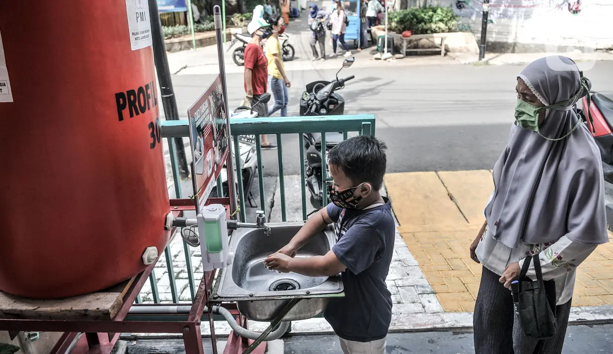 Seorang anak didampingi orangtua mencuci tangan terlebih dahulu sebelum mengikuti program BIAS di Kantor Kelurahan Tamansari, Jakarta, Selasa (24/11/2020). BIAS dipusatkan di kantor kelurahan masing-masing wilayah. (merdeka.com/Iqbal S. Nugroho)