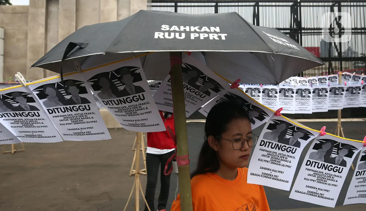 <p>Aktivis Pekerja Rumah Tangga (PRT) melakukan aksi di depan Gedung DPR, Senayan, Jakarta, Rabu (23/8/2023). Aksi dengan memasang instalasi 580 jemuran anggota DPR itu sebagai simbol kepada pimpinan, ketua fraksi, dan anggota DPR RI untuk segera membahas dan mengesahkan Rancangan Undang-Undang Perlindungan Pekerja Rumah Tangga (RUU PPRT). (Liputan6.com/Johan Tallo)</p>